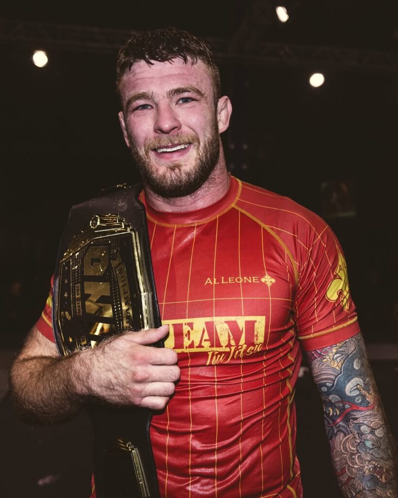 Declan Moody mostra orgulhoso o cinturão que conquistou no GP peso aberto do WNO 30, que contou com outros sete atletas.