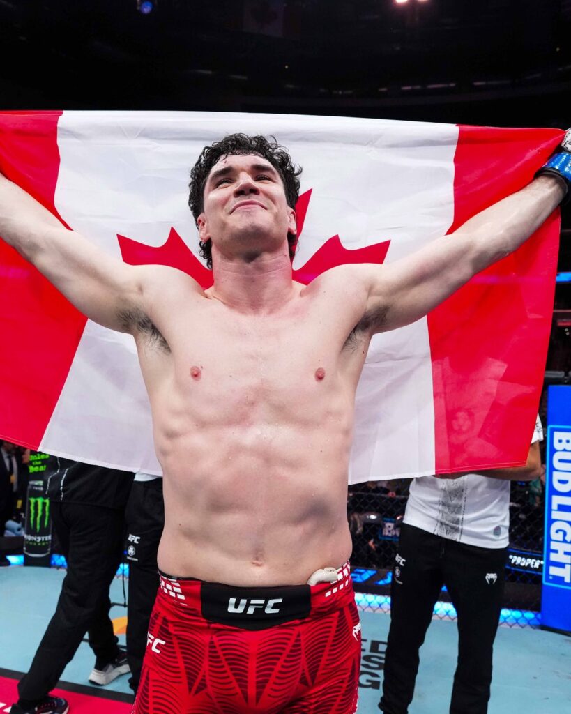 Mike Malott raises the Canadian flag in the Octagon after knocking out Joaquin Buckley in front of the Edmonton crowd.